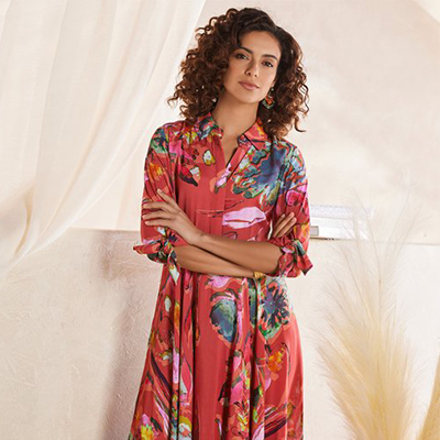 curly hair woman standing crossed arms wearing a red Soft Surroundings floral dress