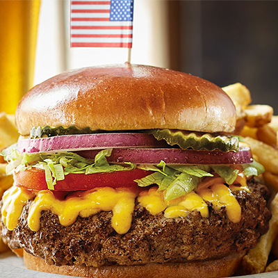 cheeseburger with a small american flag on top of bun