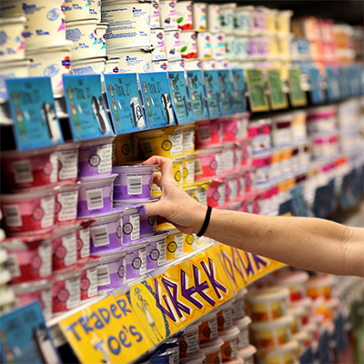 hand reaching for yogurt product on shelves